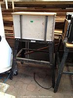 Photo showing router table with wooden top and sturdy metal legs