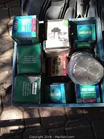 Boxes of stainless steel wire reels and socket set boxes in blue bin