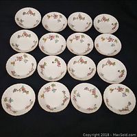 Set of 12 white porcelain MINTON berry bowls arranged in rows showing floral pattern and gold gilt edges.