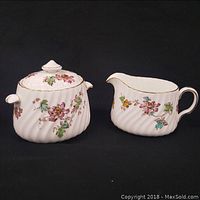 Creamer and sugar bowl set with floral gilt decorations in the Vermont pattern shown side by side
