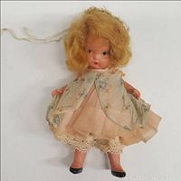 Full view of Nancy Ann Storybook Doll dressed in peach dress with floral sheer overlay and lace trim, standing against a white background.