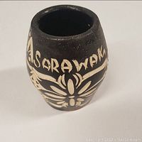 Front view showing Sarawak inscription and floral motif on vase