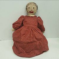 Front view of the American cloth double ended Topsy Turvy doll in red dress showing one facial side.