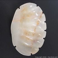 Top-down view of oval marble ashtray showing carved grooves and natural marble coloring