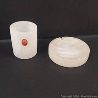 Photo showing the alabaster vessel and ashtray side by side on a black background.
