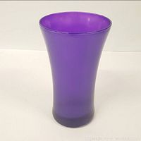 Front view of tall amethyst glass vase showing shape and color.