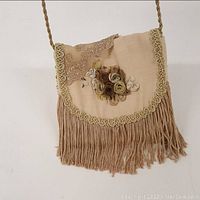 Photo of the feminine lace and ribbons evening bag showing the floral arrangement and fringe detail on the flap.