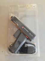 Black & Decker glue gun in clear plastic retail packaging showing front and side views