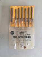 Front view of set of 6 pilot bits in yellow holder in clear plastic package showing brand and product info.