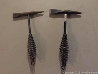 Two chipping hammers placed side by side showing their double-ended heads and spring handles.
