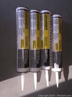 Four Grabber subfloor adhesive tubes arranged horizontally, showing full tubes with labels visible.