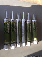 Six tubes of Titebond Subfloor Adhesive with visible labels and nozzles, arranged upright in sunlight.