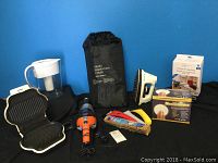 Photo showing all items in the lot together including frost prevention cover, Lean grill, iron, Bolt vacuum, Brita filter pitcher, and boxed cling wrap among other small household items.