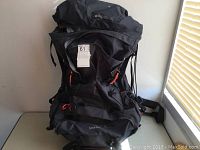 Front view of the black Mountain Warehouse Inca 80L hiking backpack showing its large size, multiple pockets, and adjustable straps.