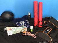 Full view of lot including two red yoga mats, Padres towel, skipping rope, water weight, puls pulley exerciser with black and orange bag, and water bottle inside cooler sleeve.