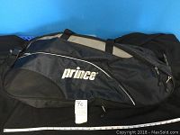 Closed view of the black and gray Prince tennis racquet bag with Prince logo and carrying handles.