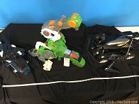 Wide shot of all three toys on black cloth background with measuring tape for reference.