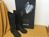 Pair of black Geox boots with box behind them, showing branding and boot profile.