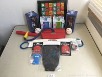 Photo of entire lot with two baseball bobbleheads in blue uniforms in boxes, two baseballs, two gel packs, a black Bed Buddy gel pad, a red KidOozie stretch band, and yellow/red small bat-like toy.
