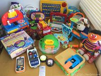 Overview photo showing the collection of more than 20 battery operated toys including laptops, vehicles, interactive pets, and play kitchen.