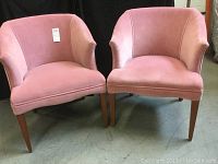 Front view of two pink velvet club style chairs