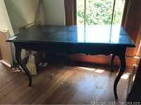 Full front and top perspective of the black console table showing curved legs and drawer.