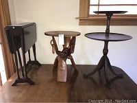 Three small tables placed on a wooden surface under a window, showing the different styles and sizes.