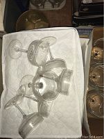 Clear Dublin brand glass stemware laid on quilted white surface, various shapes and sizes visible