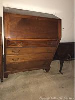 Full view of the cherrywood slant-front desk showing its shape, drawer configuration and finish.