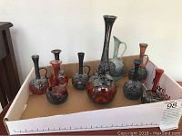 Front view of eight glass decanters and pitchers in box