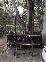 Front view of rack on patio showing three wire shelves and decorative scrollwork