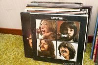 Side view of a stack of vinyl LP albums with front covers showing including The Beatles Let It Be.
