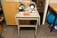 Front view of metal drop leaf table with four scales on top and original Ohaus box.