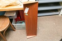 Top view of the teak floating shelf with sticker label, showing scratches and wood grain.