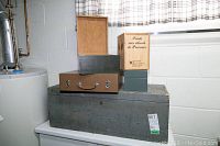 Five boxes of various sizes stacked on a white surface in front of a wall allowing clear view of labels and condition.