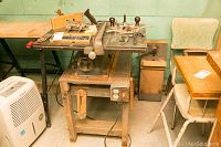 Full view of table saw on wooden stand with surrounding accessories