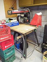 Full view of Craftsman radial arm saw mounted on a table with crates beside it.