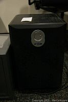 Front view of black Energy brand subwoofer speaker with silver circular emblem.