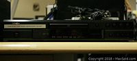 Front view of Denon DVD player showing disc tray and control buttons.
