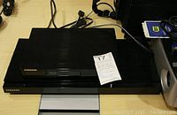 Samsung Blu-ray disc player front view on a table with power cable visible