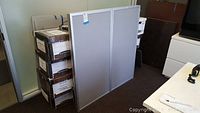 Folded whiteboard panels standing on floor with visible metal frame and back with mounting features.
