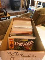 Photo showing a box of 97 comic books, with the top comic being a Spider-Man issue from Marvel Comics.