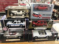 Six diecast model cars in original boxes including two large 1:18 scale and one smaller 1:24 scale model kit