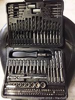 Open plastic case displaying organized drill bits, screwdriver bits, sockets, and accessories.