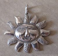 Front view of the vintage sterling silver sun face pendant showing detailed engravings, facial features, and large bail.