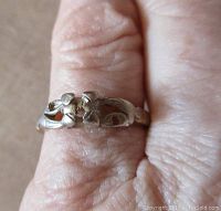 Close-up of the top side of the ring showing white gold openwork design without any stone.