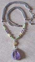 Photo showing full length of sterling silver triple chain necklace with peridot, citrine, and amethyst beads and lobster clasp.
