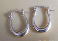 Pair of small sterling silver Vivah marked oval drop pierced earrings, hinged clasp, shown closed.