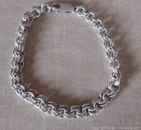 Full view of the sterling silver bracelet laid flat showing the chain and lobster clasp.