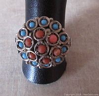 Front view of vintage ring showing cluster of turquoise and coral stones set in sterling silver with decorative bezels.